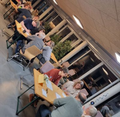 Im Gemeinschaftsraum sitzen Personen beim Rätselabend.